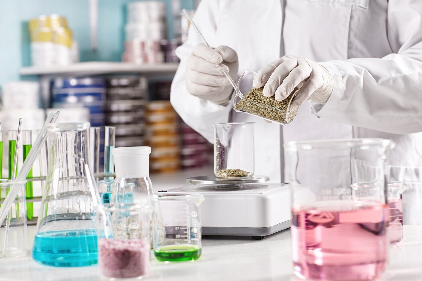 worker-surrounded-with-glass-beakers-filled-with-colorful-liquid_273609-13424